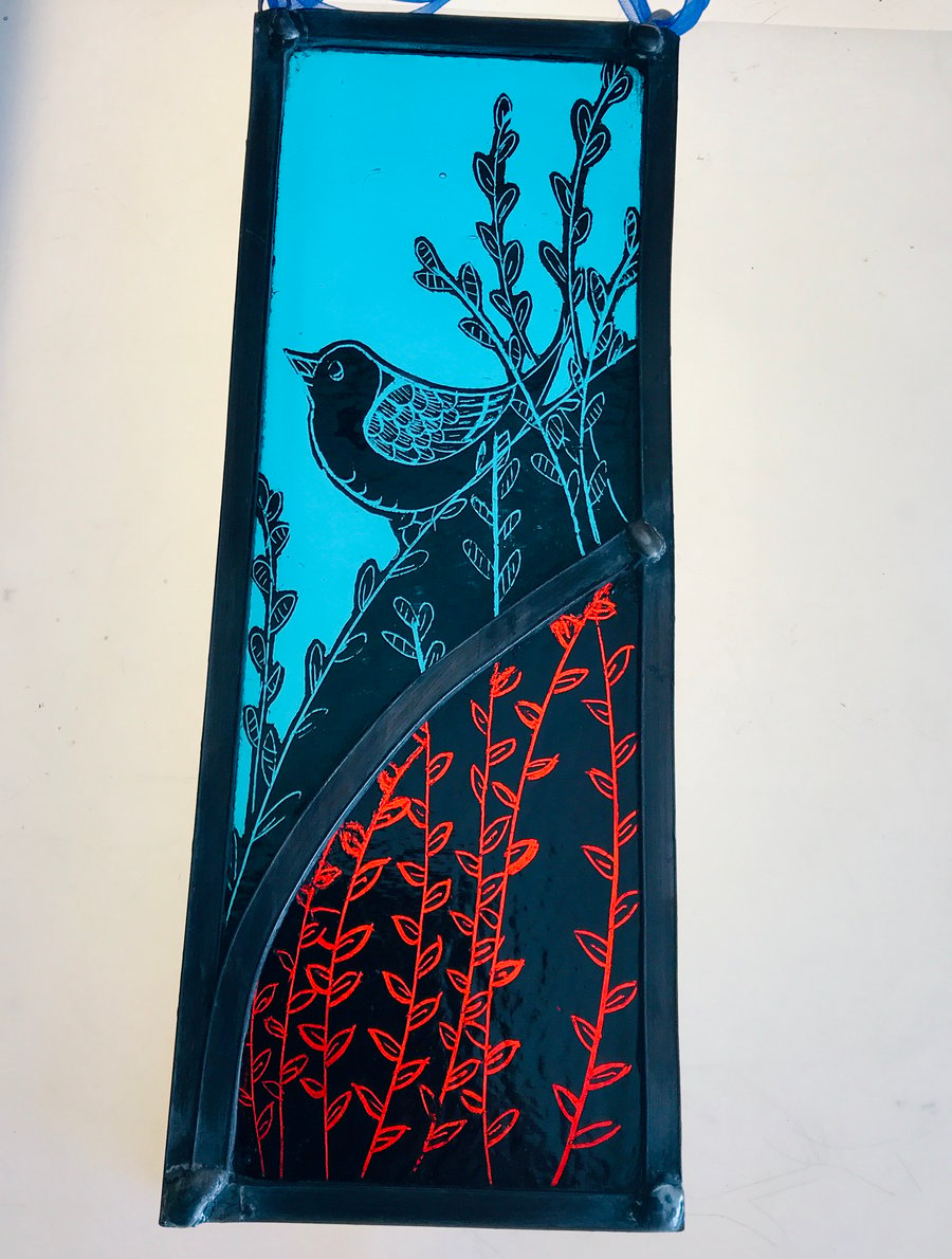stained glass panel of a bird on a branch 