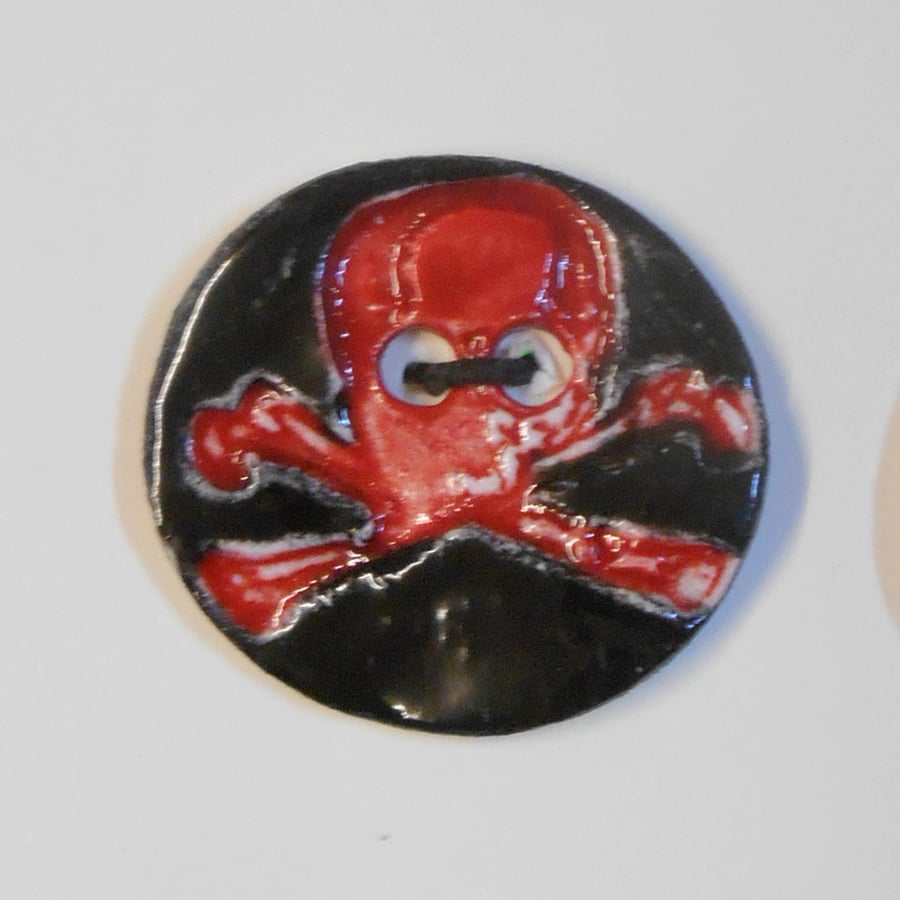 Buttons Shiny Black around a Red Skull Symbol Design on white Ceramic clay..
