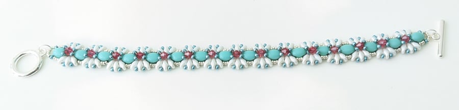 Blue and white beaded bracelet with pink crystals