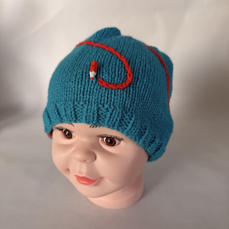 Children's hand knitted hat with pencil and scribble 