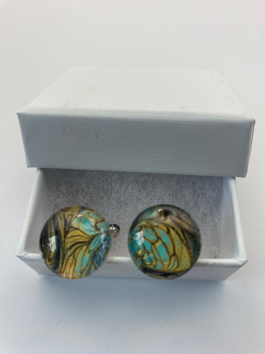 Pair of cuff links with gold, turquoise and black pigments 