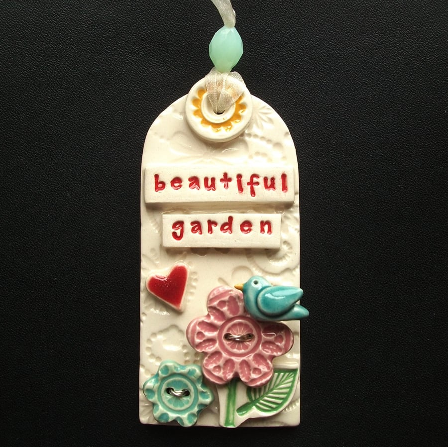 Ceramic tag decoration with bird and flower button