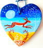 leaping moonlit hare on  a ceramic heart