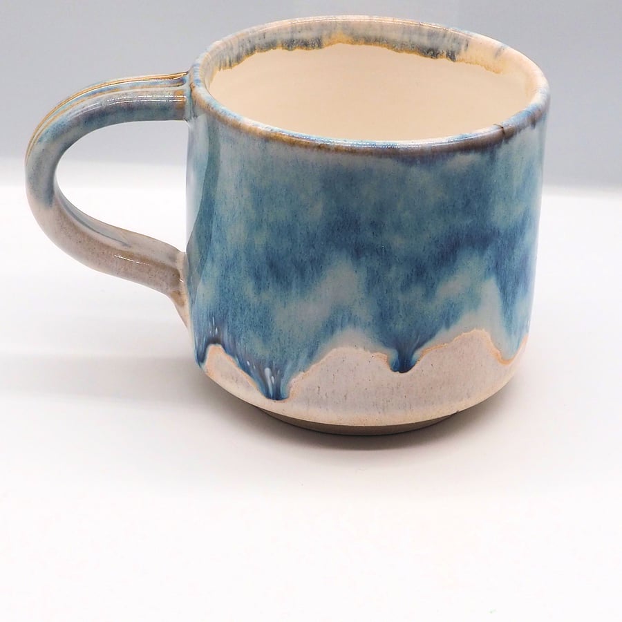 Large stoneware pottery mug finished in multi-coloured blue and white glaze.