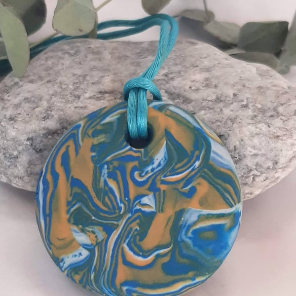 Round pendant in a turquoise, yellow and white polymer clay mix
