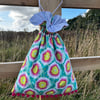 Bright floral drawstring bag with pompoms and reclaimed stripy cotton lining