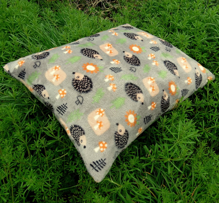 A pet cushion with a whimsical hedgehogs design.  Dog bed.  Cat bed.  
