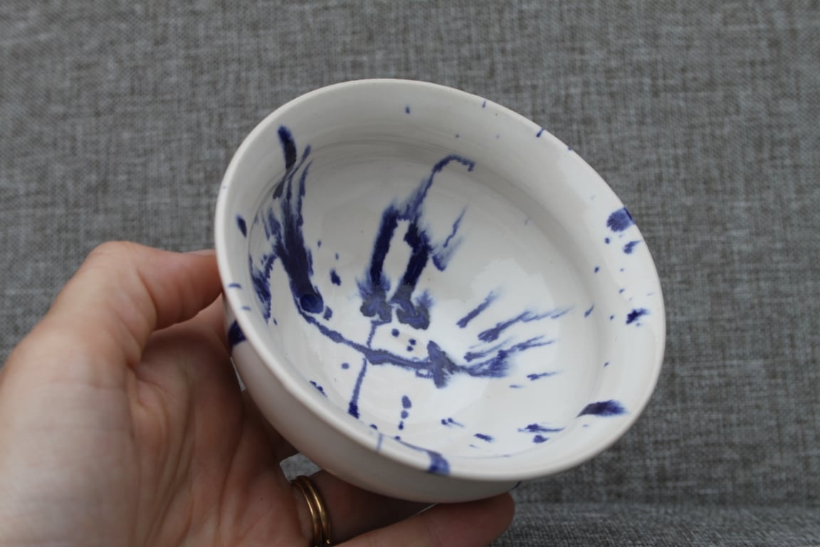 White bowl with blue paint splatter
