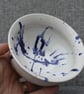 White bowl with blue paint splatter