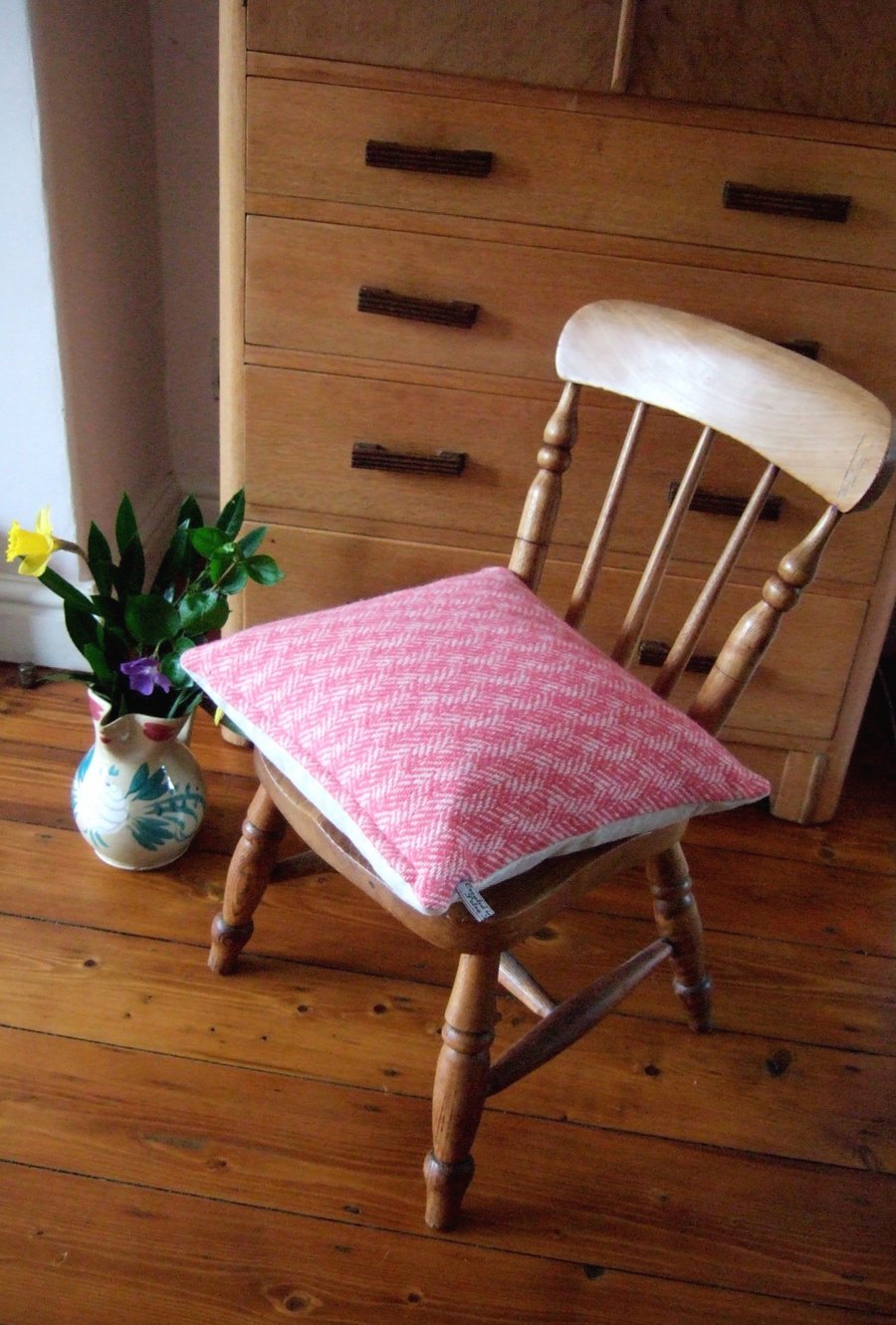 Woollen cushion in pink herringbone tweed with feather pad.