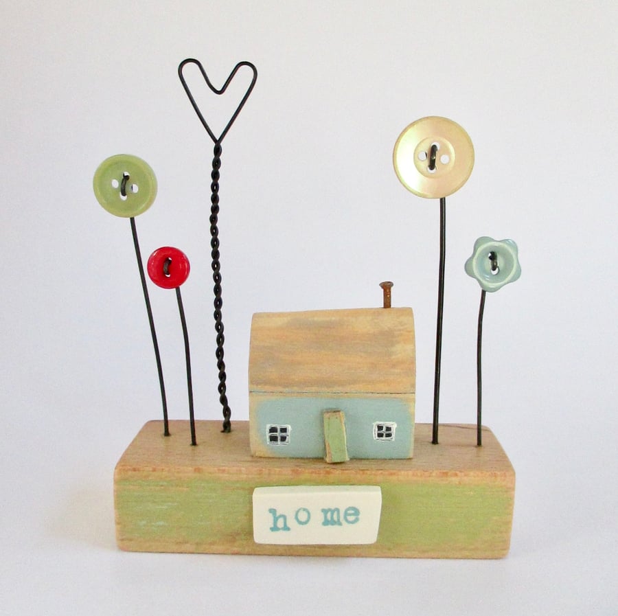 Little wooden painted house with button flower garden 'home'
