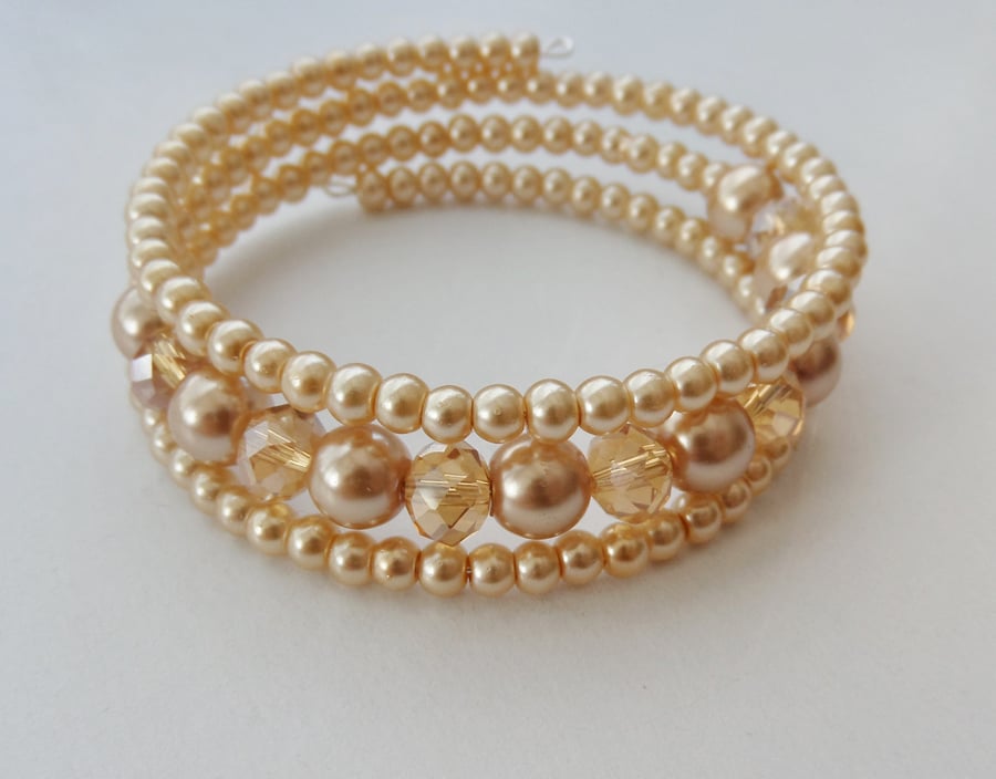 Champagne crystal rondelle and pale gold glass pearl memory wire bracelet.
