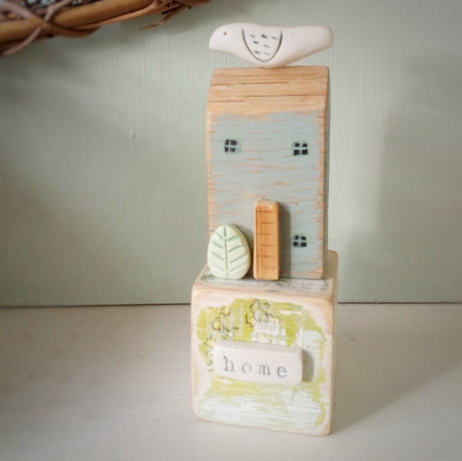 Wooden home with clay bird on vintage toy block