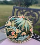Round feature cushion in vintage leafy linen with pompoms