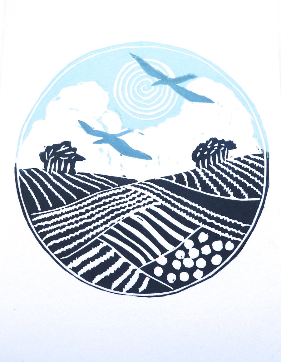 Freshly printed greetings card with two birds flying above the landscape