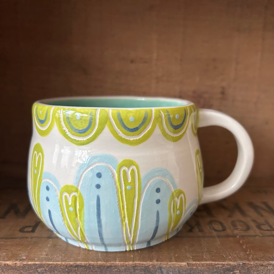 Handthrown pottery mug in shades of blue and green