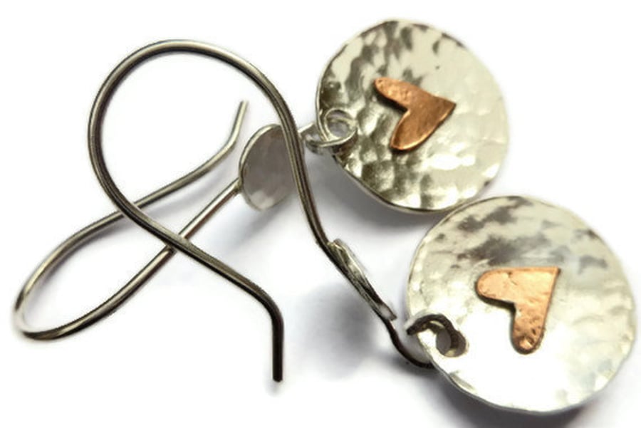 Beaten silver disc earrings with copper heart.