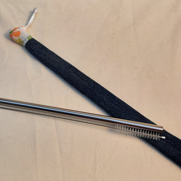 Reusable metal straw and cleaning brush with denim cover.