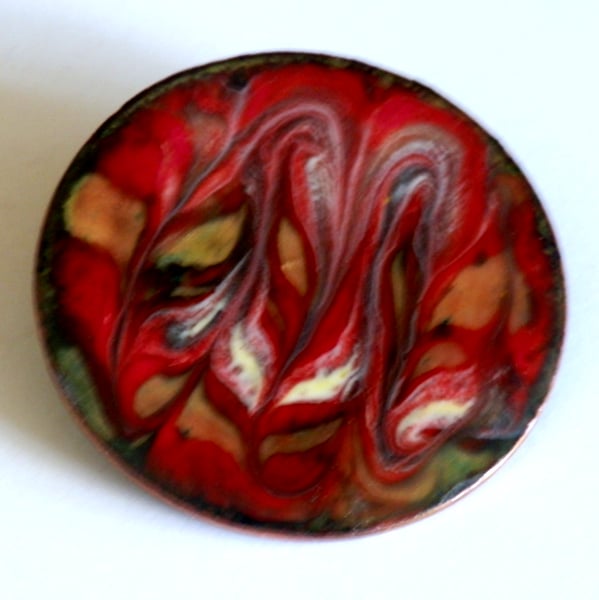 large round brooch scrolled white, dark brown and golden brown over red
