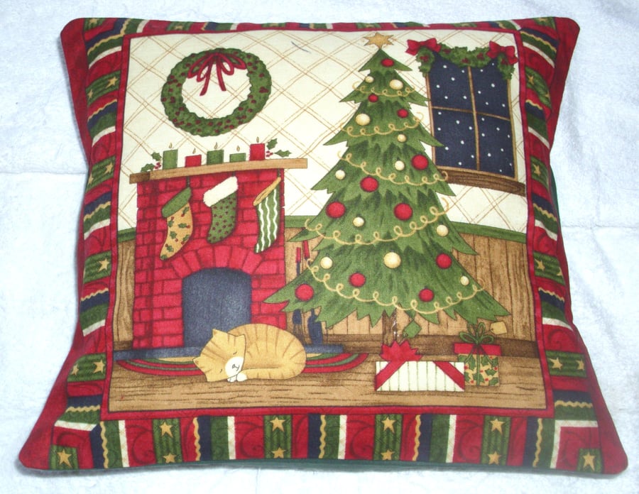 Ginger kitten under Christmas tree by the fireplace cushion