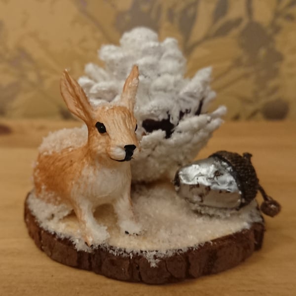 Rabbit on a log slice in snow scene
