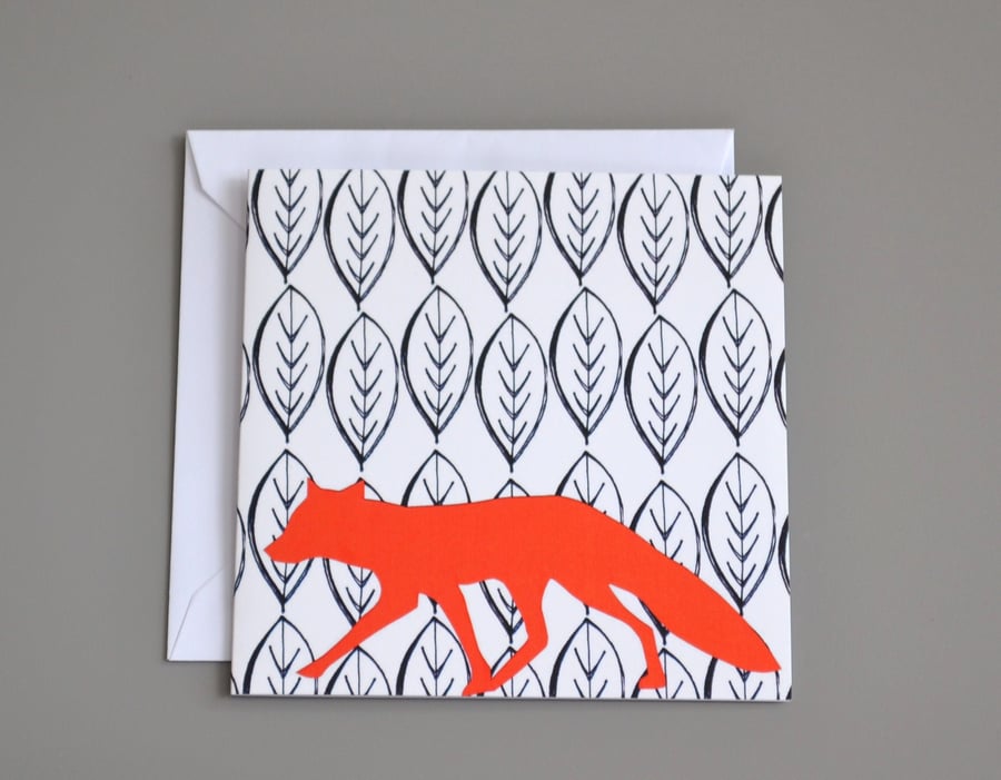 Bright orange fox in front of black and white leaf patterned background card