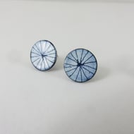 Round copper stud earrings in blue and white enamel with hand drawn detail.