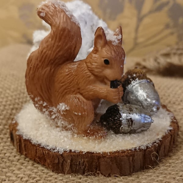 Squirrel on a log slice in snow scene 