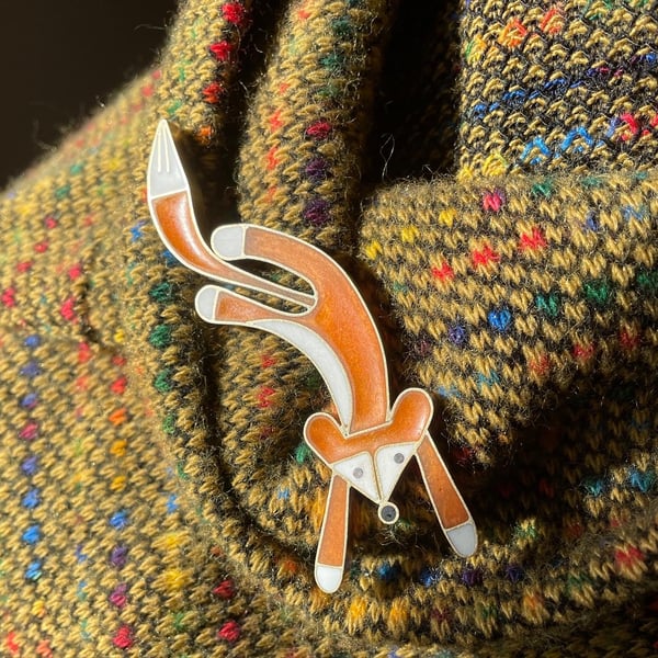 Leaping fox brooch in metal and resin.