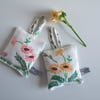 A pair of lavender bags with vintage floral embroidery