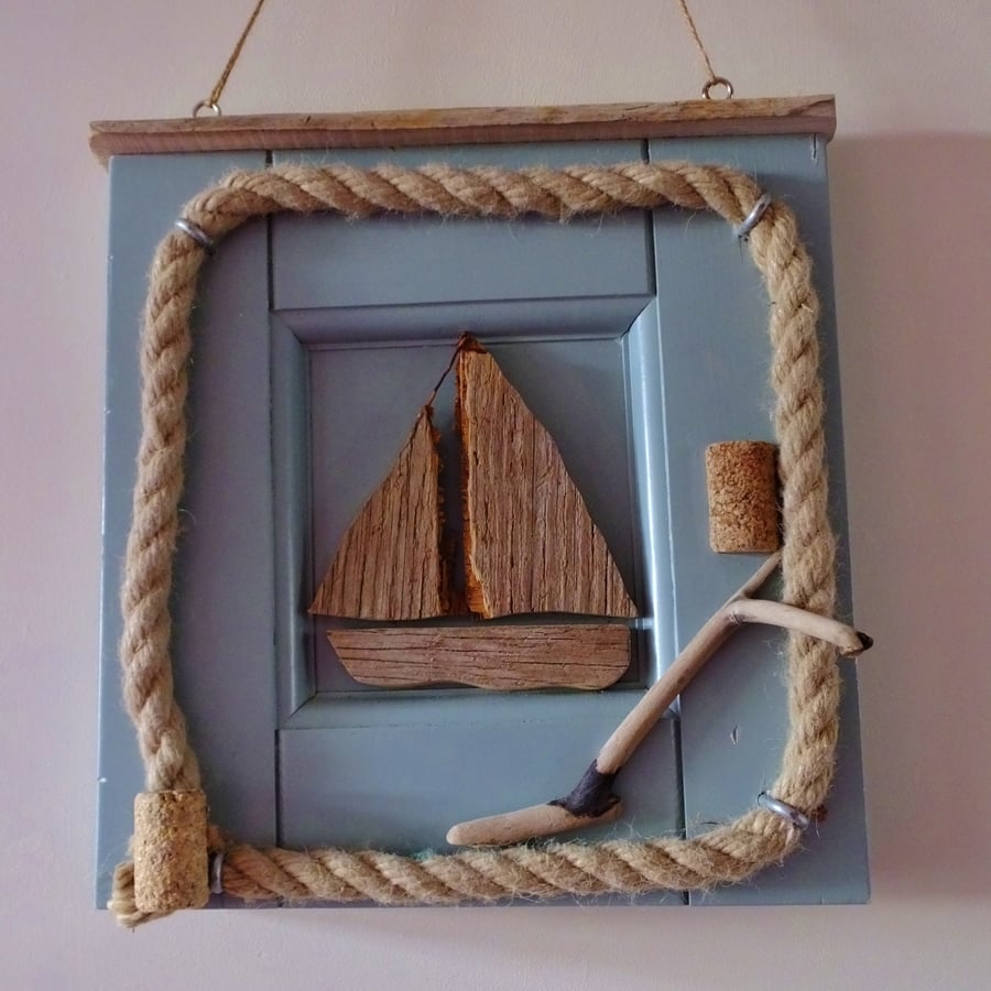 Little sailing boat or dinghy mounted in a reclaimed door panel with rope.