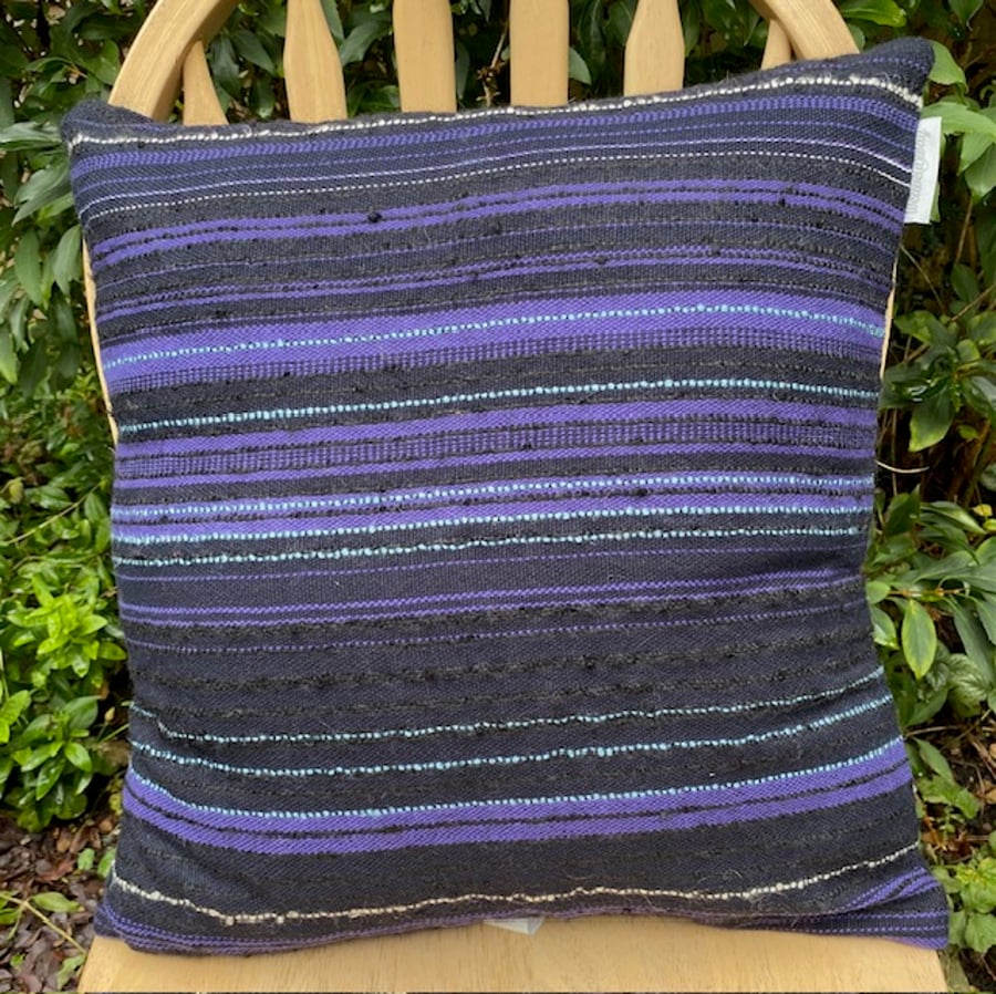 Cushion , handwoven in subtly striped textures in navy blue,  purple and black