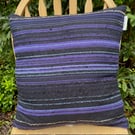 Cushion , handwoven in subtly striped textures in navy blue,  purple and black