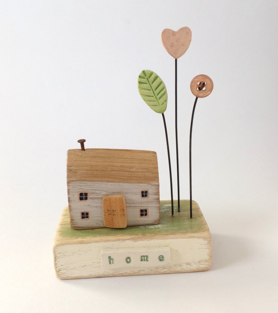 Little wooden house with love heart flower garden