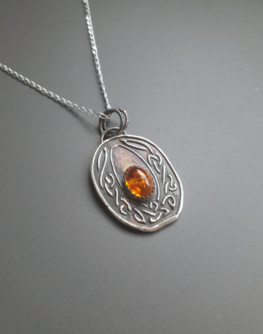 Celtic knot necklace with an amber stone