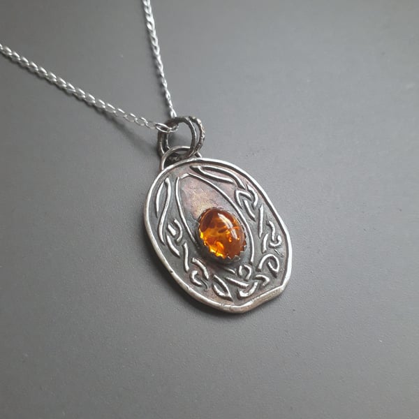 Celtic knot necklace with an amber stone