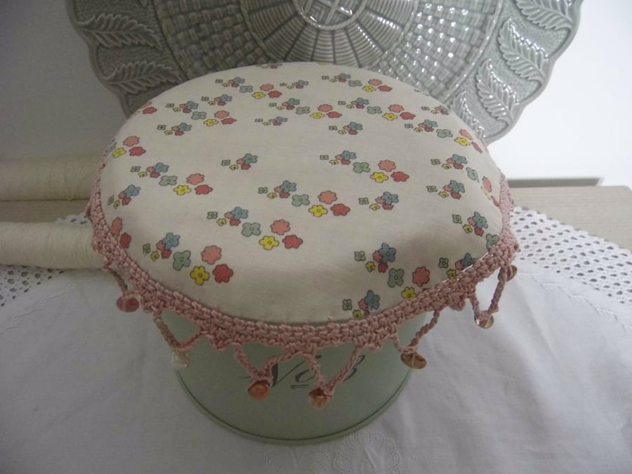 Flower print fabric jug cover, with crochet edging and glass beads.