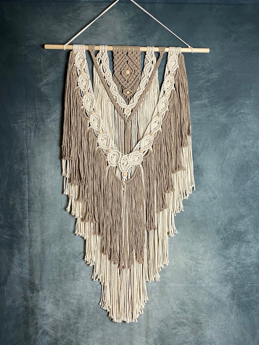 Macrame wall hanging with intricate knot design, stone and beige colours