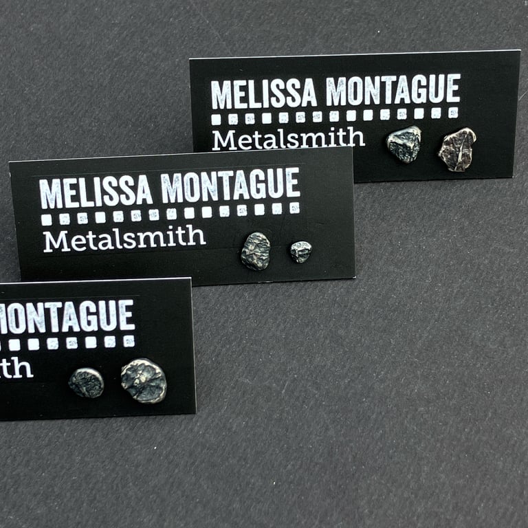 Mismatch pair of recycled silver or oxidised silver stud earrings.