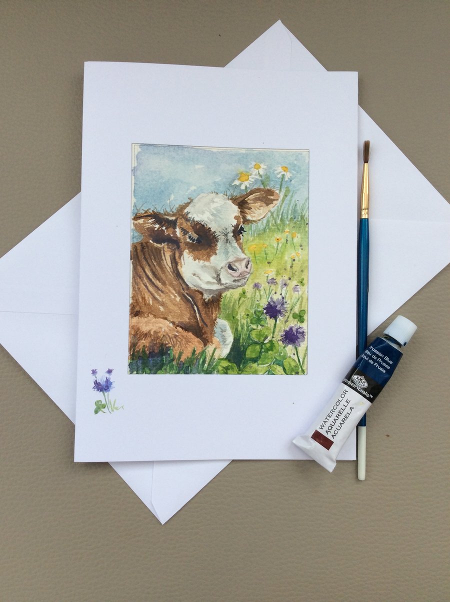 Watercolour painted card of cow in field of purple clover.