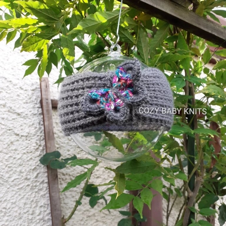 ARAN BABY EARWARMER WITH A BUTTERFLY APPLIQUED ON IT