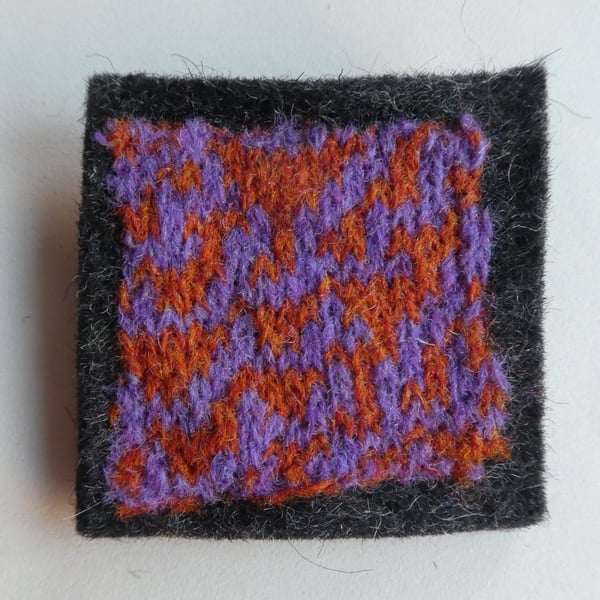 Rule 30 brooch - charcoal grey with orange and purple, square, needle felted.