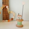 Tiny oak house with clay heart on vintage wooden bobbin