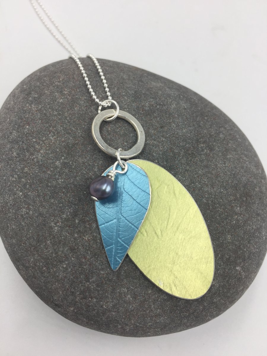 Layered anodised aluminium pendant in blue and green with silver ring and pearl