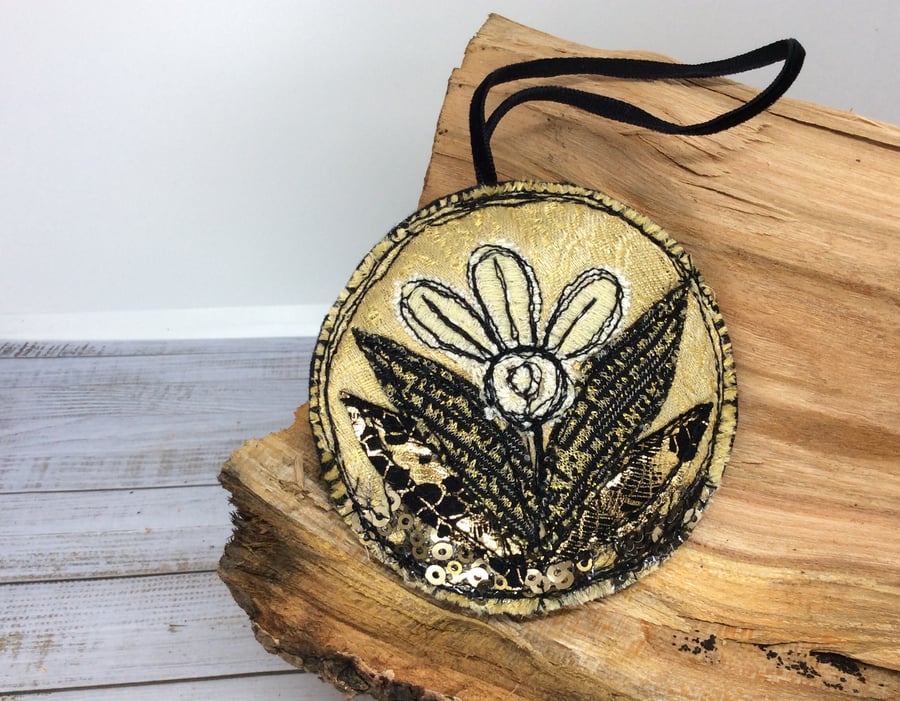 Up-cycled embroidered gold flower decoration. 