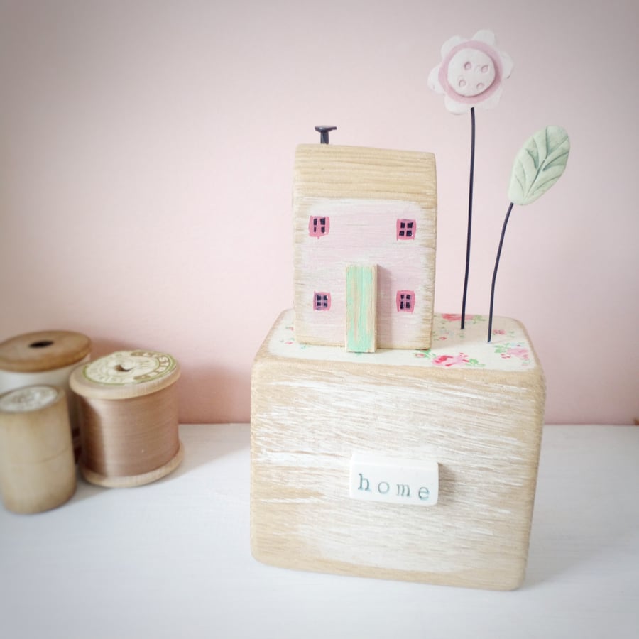 Wooden house on oak block with clay flower 'home'