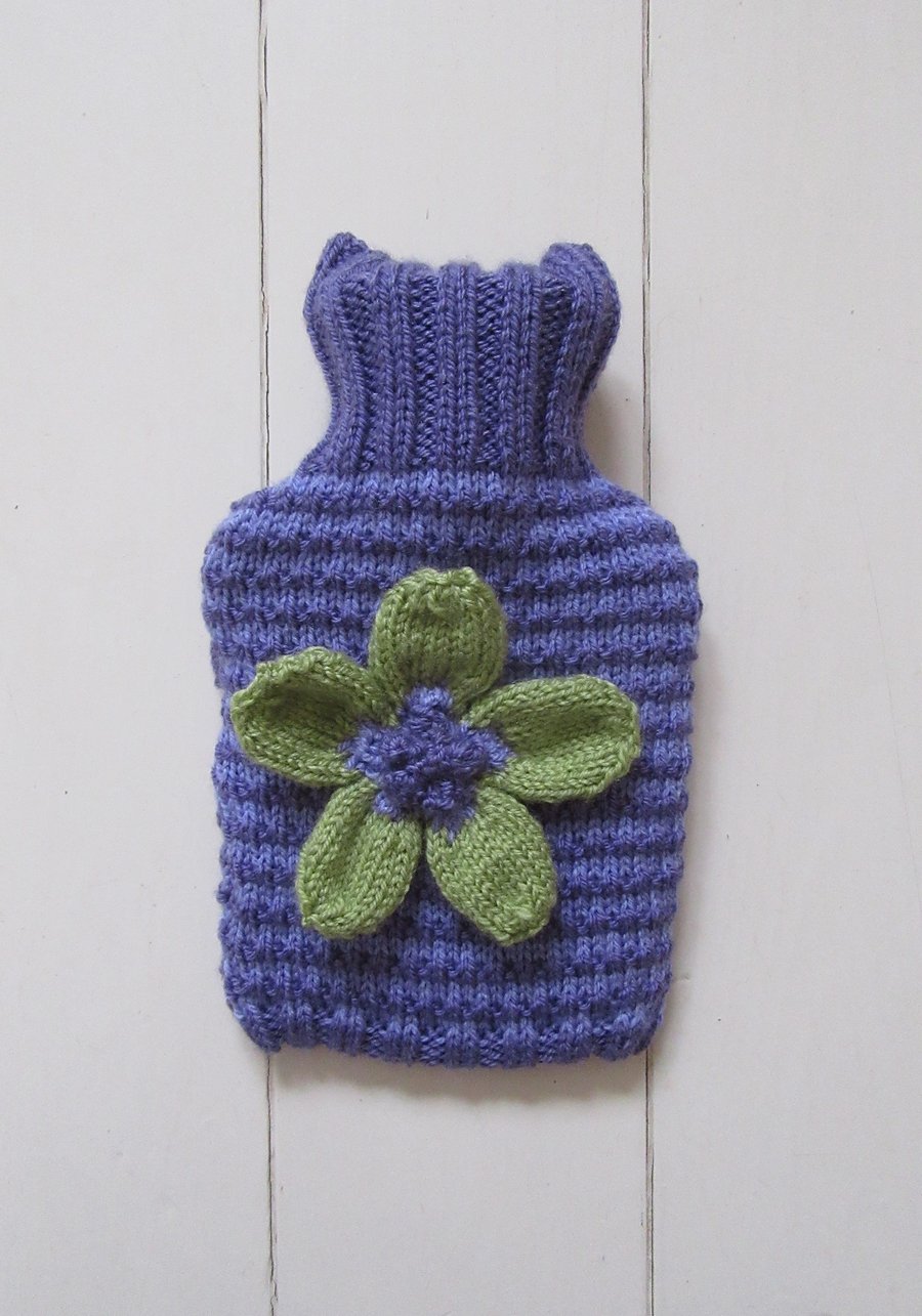 Knitted stripy hot water bottle cover with daisy flower