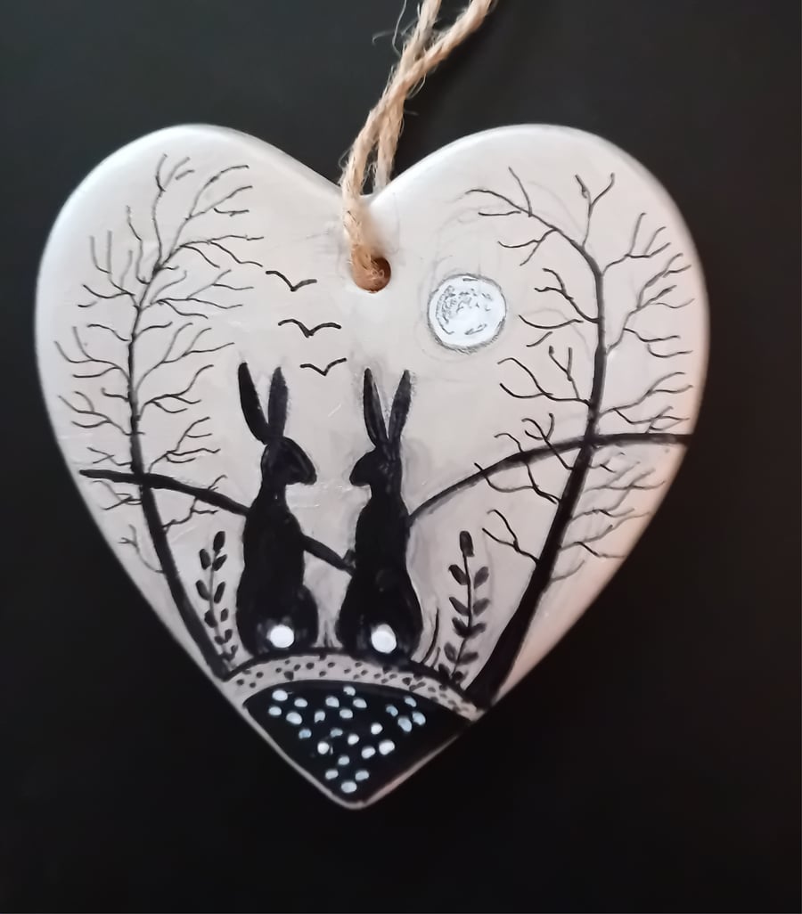 Silver black hares on a ceramic heart  