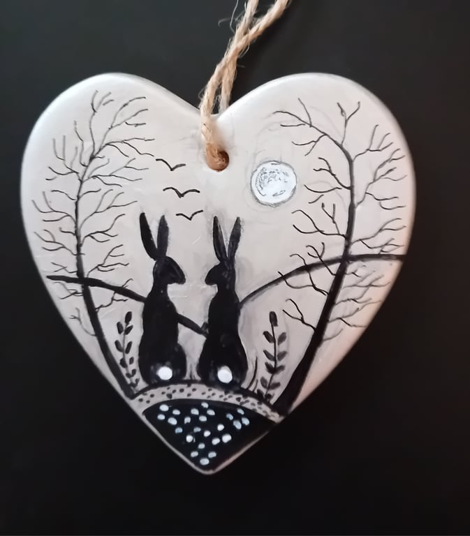 Silver black hares on a ceramic heart  
