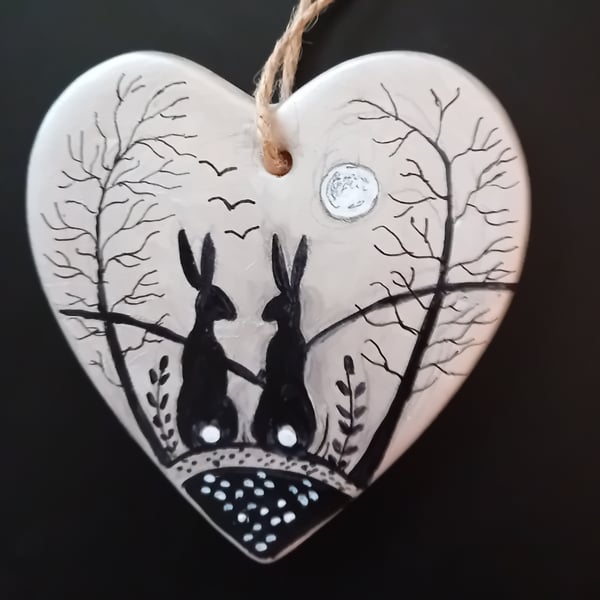 Silver black hares on a ceramic heart  